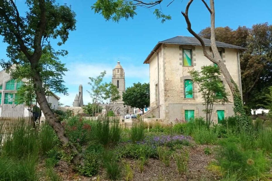 Vue générale du parc Jean-et-Soizick-Fréour à Batz-sur-Mer avec maison aux volets décorés et église Saint-Guénolé en arrière-plan