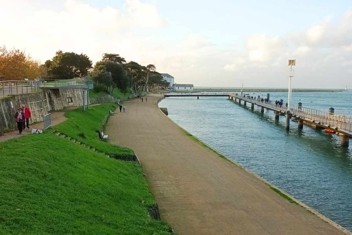 Sentier montant du Mont Lénigo au Croisic avec vue sur la rade, passerelle en bois et promeneur
